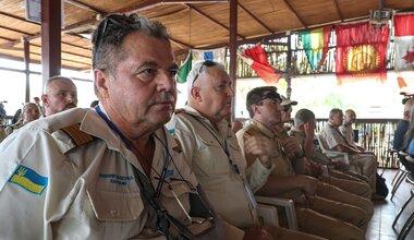 A group of Ukrainian peacekeepers sitting in a row at the memorial for the fallen Ukranian peacekeeper.